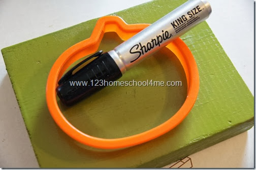 grab your piece of painted scrap book, a pumpkin cookie cutter, and a sharpie grab your piece of painted scrap book, a pumpkin cookie cutter, and a sharpie
