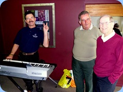 Peter Littlejohn trying out Delyse Whorwood's Technics KN6500 keygboard with Ken Mahy and John Beales watching-on.