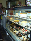 Fresh cakes, tarts and pastries fill the glass case.