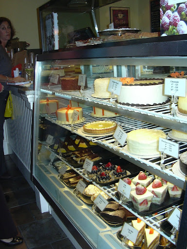 Fresh cakes, tarts and pastries fill the glass case.