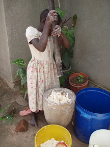 One of the neighbor girls grinds cassava the old-school way.