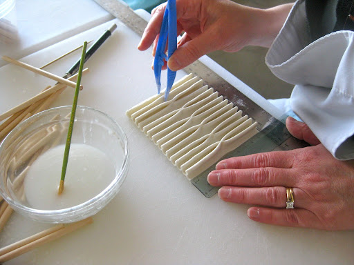 She pinches together every two. I love how it looks like an imaginary thread is going through the gum paste!