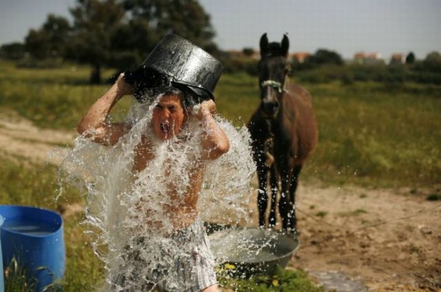 A boy washes soap off while taking a bath next to shacks in Moita, near Lisbon April 8, 2011.  REUTERS/Rafael Marchante (PORTUGAL - Tags: SOCIETY)