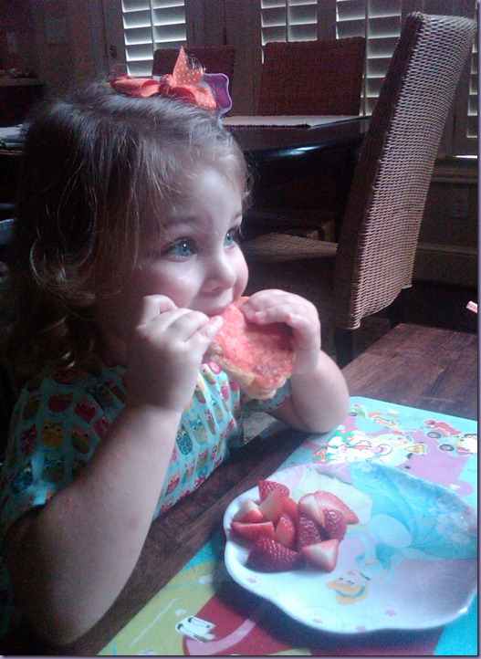 happy girl eating pink grill cheese