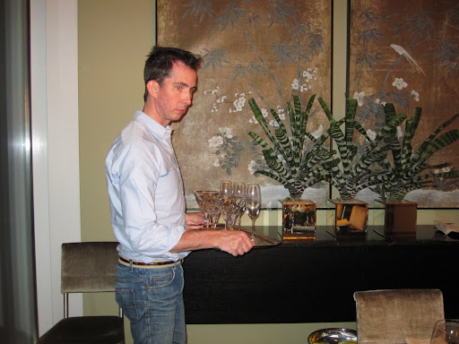 Setting up a tray of extra cocktail glasses and champagne glasses in the back of the dining room.