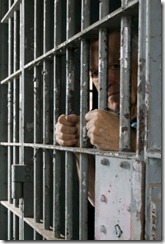 iStock_000001434367XSmall Man in Jail looking sideways through bars