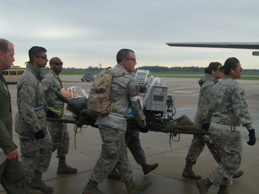 Military personnel carry a mannequin representing a person injured in a potential catastrophe. (Photo credit: Jennifer Moore)