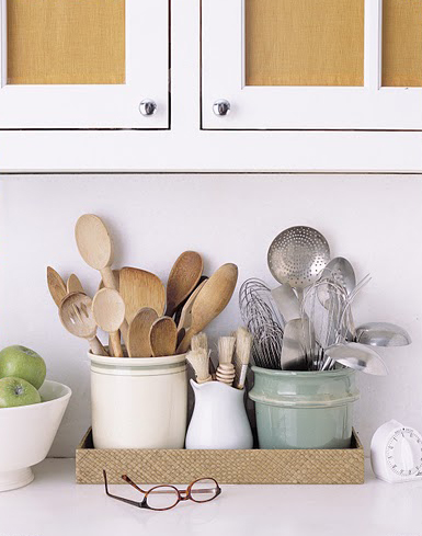 Martha likes to keep metal and wooden utensils separated. In this case, they are in different pots, within a woven tray. Martha likes to keep metal and wooden utensils separated. In this case, they are in different pots, within a woven tray.