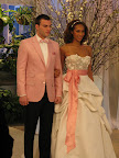A Monique Lhuillier gown with meringue texture is shown here while the groom is showing off a pink jacket and black pants from Kleinfeld. A Monique Lhuillier gown with meringue texture is shown here while the groom is showing off a pink jacket and black pants from Kleinfeld.