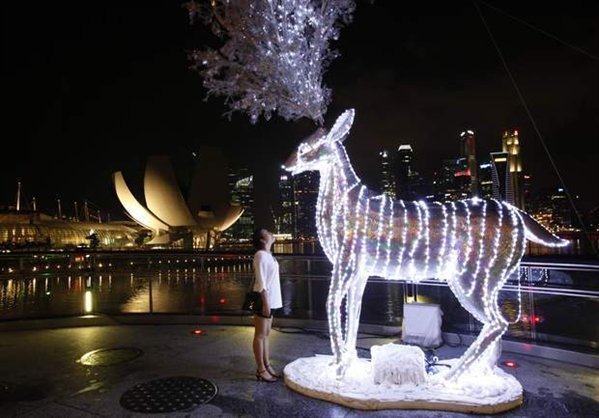 [a-tourist-looks-at-a-reindeer-display-lit-up-in-preparation-for-christmas-celebrations-in-front-of-the-skyline-of-the-finan599x0%255B2%255D.jpg]