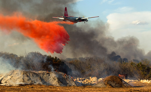 A plane dumps fire retardant on a 30-acre grass fire in Leander on Monday, August 15, 2011. The blaze destroyed 15 homes. Jay Janner / statesman.com