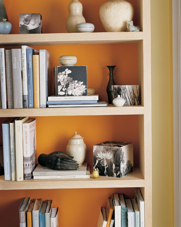 Fall: Paint the backs of bookcases in a bright orange for the fall season -- or just line them with colored paper -- to give your case a cozy touch. Fall: Paint the backs of bookcases in a bright orange for the fall season -- or just line them with colored paper -- to give your case a cozy touch.