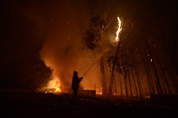 A firefighter battles a fire in New South Wales, 9 January 2013. PA