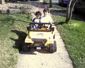 Kai and Eidan riding on the neighbor's battery powered mini Jeep