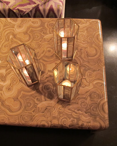 These Albert Hadley hurricane lanterns really glow on the table's golden fabric.
