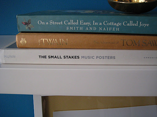 A close up of the books on the shelf under the poster. We were inspired by rock posters when we came up with the idea and loved that the bottom book hinted at that.