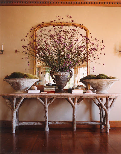 Over-sized moss arrangements anchor a whimsical wooden console, putting the focus on a truly fantastic center arrangement.