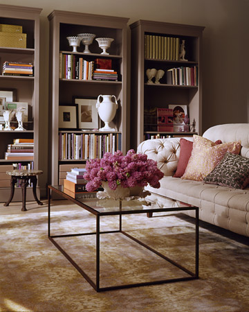 With a little doctoring, unfinished bookcases from a furniture store can take on a built-in look, and add architectural interest to a room.