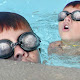 The image is a merging of two pictures of the same kid swimming laps in a pool.