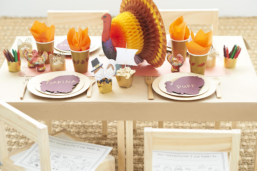 For the kids' table, I used brown craft paper as a tablecloth. Kids can decorate the paper with supplies such as crayons, stickers, or rubber stamps. I used flameless candles (the battery-pack ones) wrapped with the extra strips of gold-punched paper to create a For the kids' table, I used brown craft paper as a tablecloth. Kids can decorate the paper with supplies such as crayons, stickers, or rubber stamps. I used flameless candles (the battery-pack ones) wrapped with the extra strips of gold-punched paper to create a