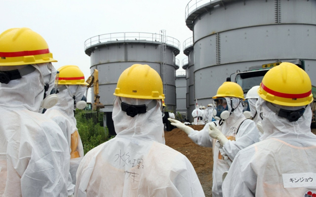 Workers at leaking water tanks at the Fukushima nuclear plant. Photo: Japan Pool / AFP / Getty Images