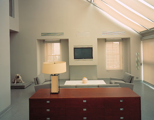 Symmetry can be used to create a focal point in a room. Here, a pair of chairs defines a cozy sitting area. The windows along the far wall frame the space.