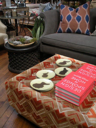 Silhouette dishes and a great read decorate this catchy ottoman.