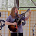 Joe Jencks tunes his bouzouki.  
"Never tell the airlines you're carrying a bouzouki"