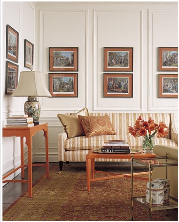 Doses of hot orange visually organizes disparate elements in this formal living room.