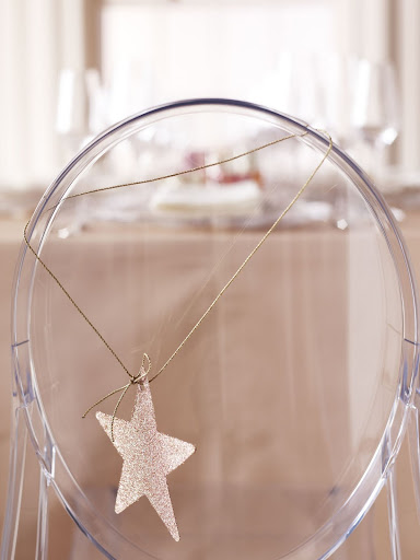 We put the five-pointed wonder on display wherever we could -- like on this chair. Hanging from it on a golden cord is a dressed-up paper star; we made it by spraying the star with glue, then shaking glitter over it. (Martha Stewart Weddings) We put the five-pointed wonder on display wherever we could -- like on this chair. Hanging from it on a golden cord is a dressed-up paper star; we made it by spraying the star with glue, then shaking glitter over it. (Martha Stewart Weddings)