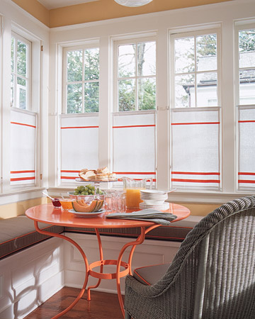 Yellow and orange together are cheerful beyond words. We took an outdoor garden table, had it painted, and used it in this charming breakfast nook. The orange welting on the cushions and stripes on the modern take of a cafe curtain enhance the effect.