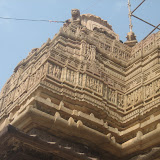 There is a standing figure of a goddess in middle tier, where she is shown with four hands carrying trisula and khatvanga. Upper and lower tiers have many images of dancers, couples, gods and goddesses.
