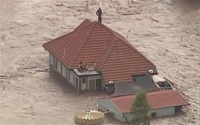 People are trapped by floodwaters on the rooftop of a house in Grantham, Australia, a township between Toowomba and Brisbane, 11 January 2011. REUTERS