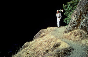America The Beautiful - A hiker in the Wild & Scenic Area along southern Oregon's Rogue River near Paradise Lodge. This photograph was taken just above Blossom Bar and Devil's Staircase, for boaters and rafters two of the toughest stretches along the entire course of this river. Paradise is a fine lodge, but it is best reached by powerboats that traverse the river from Gold Beach. The Rogue is a fine salmon and steelhead fishery. Be sure to bring your camera. The scenery is breathtaking, especially in the spring and fall.