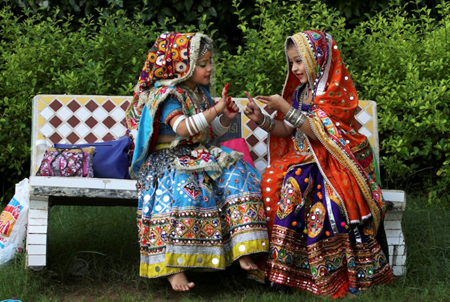 Due bambine in abiti tradizionali in vista della festa di Navratri, che dura nove notti ognuna delle quali i fedeli indù venerano una diversa forma della dea Durga.