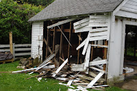 Tearing off the siding, so that the garage can be pulled down