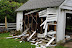 Tearing off the siding, so that the garage can be pulled down Tearing off the siding, so that the garage can be pulled down