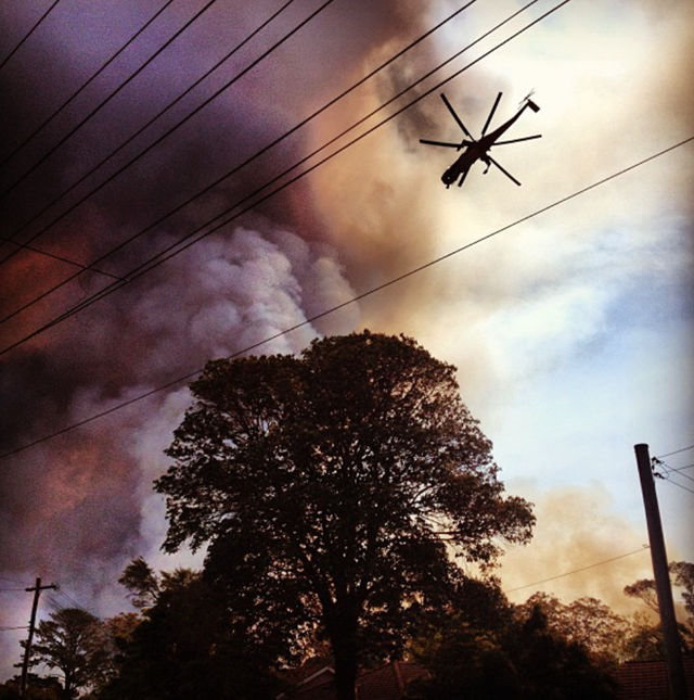 A helicopter flies over a fire front in the Blue Mountains of New South Wales, 19 October 2013. Photo: raddlegrams / Instagram