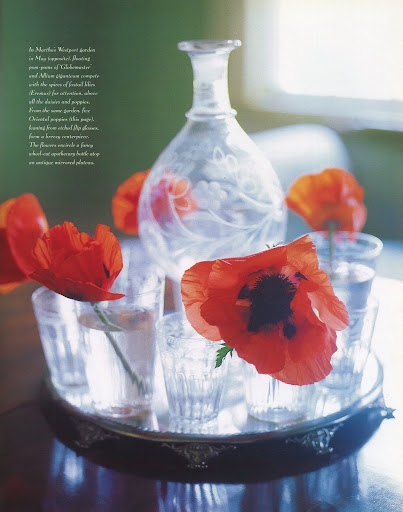 Five Oriental poppies, leaning from etched flip glasses, form a breezy centerpiece. The flowers encircle a fancy wheel-cut apothecary bottle atop an antique mirror plateau. (The Best of Martha Stewart Living -- Arranging Flowers)