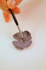 Here, she preps the petals before attaching them to the bud.