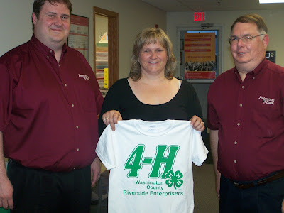 Terry Engelken and Jamie Collier of Federation Bank present club shirts to Riverside Enterprisers leader, Ann Lampe.  Photo Courtesy:  Washington County Extension.