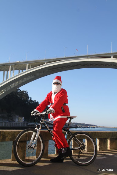 De kerstman brengt in Porto cadeautjes met de fiets