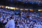 Audience members in their white and light blue ponchos