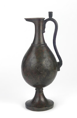 Ewer | Origin:  Iran | Period: 9th-10th century  Abbasid period | Details:  Vibrant metalworking industries in gold, silver, iron, and copper thrived in Basra. Craftsmen there specialized in manufacturing locks, mirrors, and other utensils. This pear-shaped vessel is similar to a bronze ewer that was made in Basra and is now in the Tiblisi Museum in Georgia, near Russia. The inscription around the neck of the Tiblisi ewer gives the craftsman's name and Basra as its place of manufacture. | Type: Brass | Size: H: 16.5  W: 43.7  cm | Museum Code: F1945.13 | Photograph and description taken from Freer and the Sackler (Smithsonian) Museums.