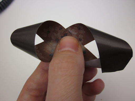 Next you fold and tape together the loose ends to make a figure eight shape. If you want triangles to hold their shapes at the ends, just press them down a little to get a crease.