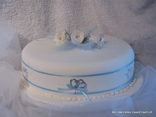 single tier wedding cake with blue and seaside accents and white sugar rose