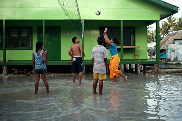 Life goes on: young people play a game of volleyball in ankle-deep sea water in Funafuti, an atoll that is Tuvalu’s capital. Amelia Holowaty Krales