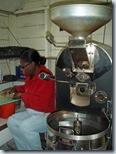 Pamsy sorts beans with coffee roaster to her left