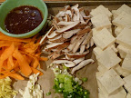 Ingredients assembled-clockwise from right-tofu, scallions, garlic, ginger, carrots, sauce ingredients, shiitake mushrooms.