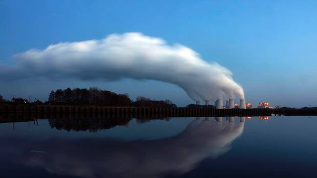 Steam billowing from the cooling towers of Vattenfall's Jaenschwalde brown coal power station is reflected in the water of a lake near Cottbus, eastern Germany, in this file picture taken in December 2009. PAWEL KOPCZYNSKI / REUTERS